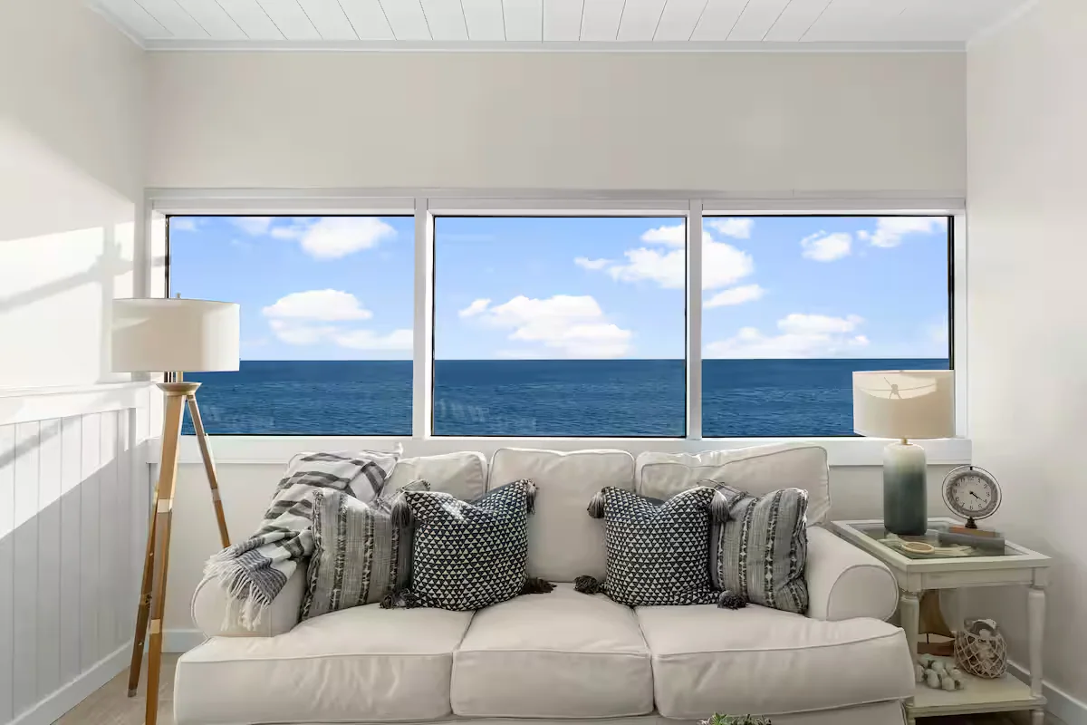 Living room seating beside windows overlooking the ocean