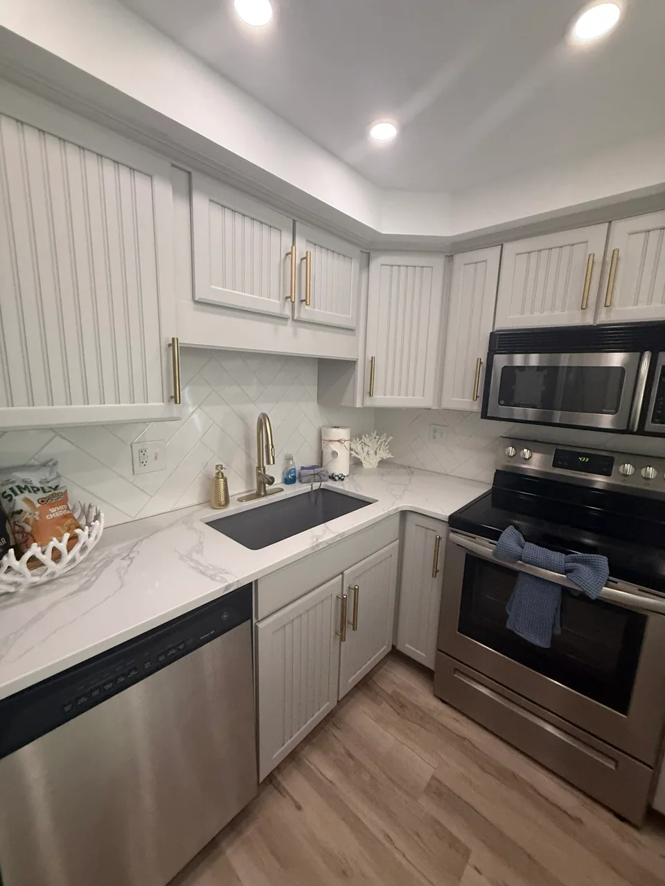 Kitchen with white cabinetry and dark countertops