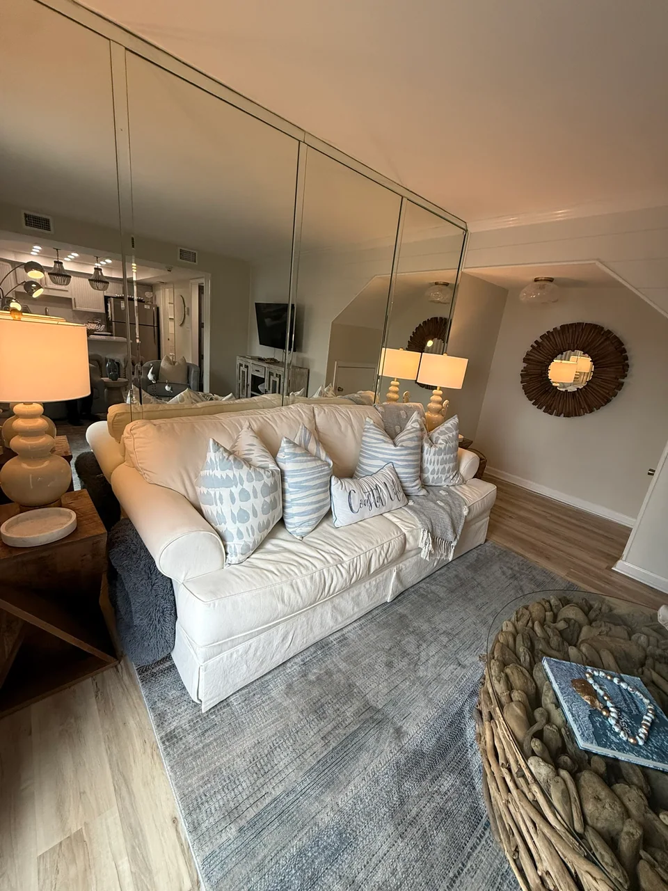 Furnished living room with a white sofa and mirrored wall